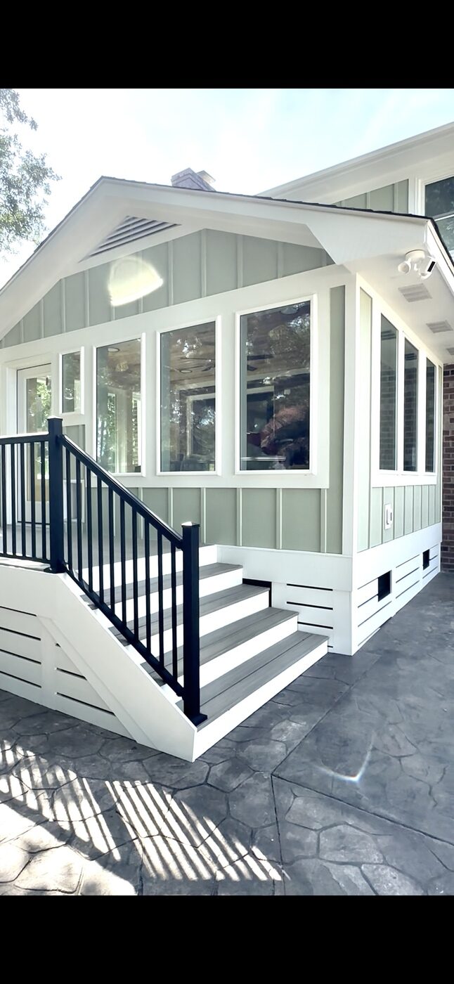 White porch conversion with windows, entry steps and black railing